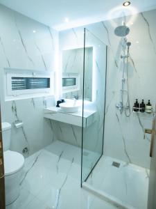 a white bathroom with a sink and a shower at Klitiou 7 Boutique Hotel in Athens +20 photos