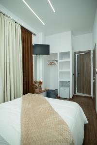 a bedroom with a white bed and a window at Klitiou 7 Boutique Hotel in Athens