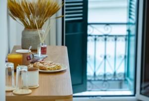 a table with a plate of food and orange juice at Klitiou 7 Boutique Hotel in Athens