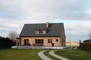 a brick house with a circular driveway in front of it at Villa Ultima Thule in Ostend