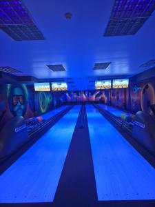 a bowling alley with blue lights and graffiti at Hotel La Mar in Kielce