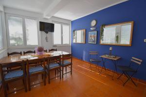 a dining room with blue walls and a table and chairs at Apartman Balen J. in Banjol
