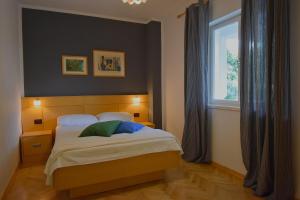 a bedroom with a large bed with a window at Apartman Balen J. in Banjol