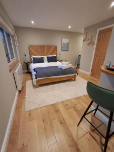 a bedroom with a bed and a green chair at An Sealladh in Fort William