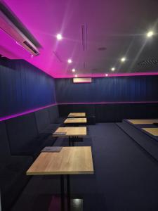 a row of tables in a room with purple lights at Hotel La Mar in Kielce +39 photos