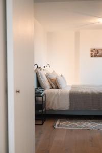 a bedroom with a bed with white walls at Villa Ultima Thule in Ostend
