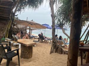 a group of people sitting in chairs on the beach at The Coast Haven in Tangalle