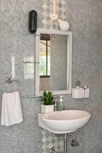 a bathroom with a sink and a mirror at Mangalmurti Farmstay in Pendur