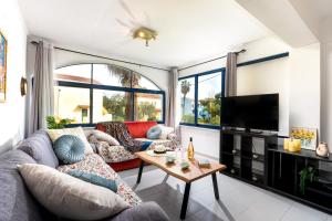 a living room with a couch and a tv at Blue Bay Apartment in Gouvia