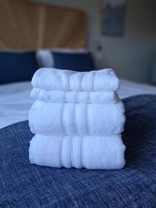 a stack of towels sitting on top of a bed at An Sealladh in Fort William +3 photos