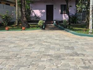 a stone driveway in front of a house at White Sands Cottage in Alleppey