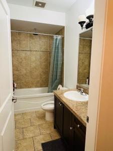 a bathroom with a sink and a toilet and a tub at 2 Bedroom plus den 2 Bathroom apartment in Surrey