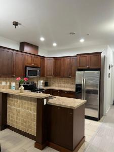 a kitchen with wooden cabinets and a stainless steel refrigerator at 2 Bedroom plus den 2 Bathroom apartment in Surrey