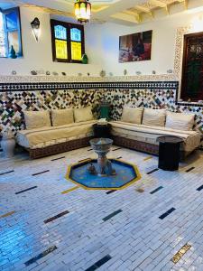 ein Wohnzimmer mit Sofa und Tisch in der Unterkunft Riad Dalal in Fès