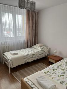 a bedroom with two beds and a window at Apartament Centrum Możliwość wystawiania Faktur- WI-FI in Suwałki