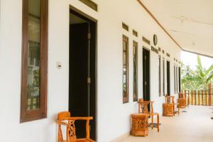 a row of chairs on the side of a building at Omah Ulin in Bandongan