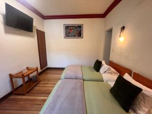 a hotel room with two beds and a tv at Terra Sagrada Cusco in Cusco