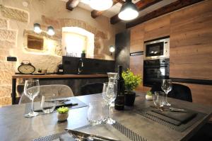 a table with wine glasses on it in a kitchen at Villa Angelina - design stone house in Markovac in Višnjan