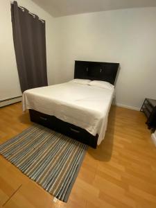 a bed in a small room with a rug at Private Room near NYC! in Paterson