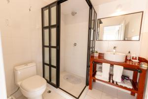 a bathroom with a toilet and a sink and a mirror at Solara Art House Hotel in Cusco