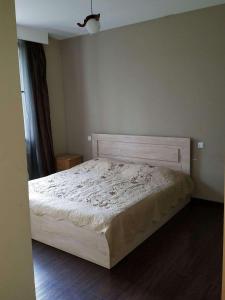 a bedroom with a white bed with a wooden headboard at Elite House in Bakuriani +7 photos