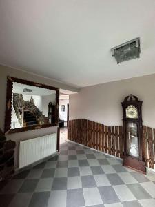 a hallway with a grandfather clock and a mirror at Elite House in Bakuriani