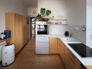 a kitchen with white counters and wooden cabinets at Jugendstil Ferienwohnung Neustadt in Neustadt an der Weinstraße