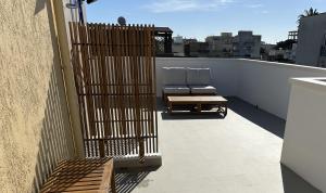a balcony with a chair and a bench on a roof at Dune House in Ginosa Marina