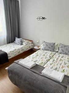 a bedroom with two beds and a table with a window at Apartament Korczaka możliwość wystawiania Faktur, WI-FI in Suwałki