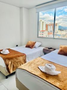 a room with two beds and a large window at Hotel Terraza in Floridablanca