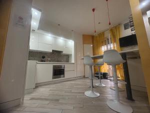 a kitchen with two stools and a kitchen with white cabinets at La Concordia in Novi Ligure +7 photos