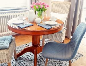 a dining room table with chairs and flowers on it at Haus Sonneneck 1 in Bad Zwischenahn