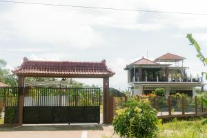 a gate in front of a house with a gazebo at Omah Ulin in Bandongan +2 photos