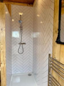 a bathroom with a shower with a white wall at Willow Court Farm, The Copper Castle & Petting Farm, 8 min to Legoland & Windsor, 15 min to Lapland UK in Windsor +20 photos