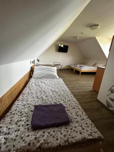 a large bed in a room with an attic at Penzion U Ježka in Nedakonitz