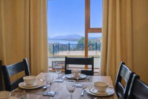 a dining table with a view of a large window at 5 Bedroom House By Travel Lets Holiday Homes Donegal With Sweeping Lake & Hill Views in Carrigart