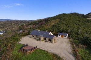an aerial view of a house on a hill at 5 Bedroom House By Travel Lets Holiday Homes Donegal With Sweeping Lake & Hill Views in Carrigart