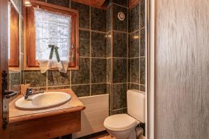 a bathroom with a sink and a toilet and a window at Chalet Savoyard in La Clusaz +7 photos