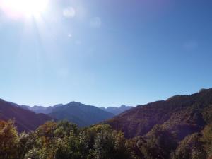 a view of the mountains with the sun in the sky at Nebin - casa vacanze Valle Maira in Stroppo +1 photo