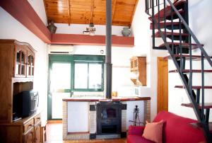 sala de estar con chimenea y sofá rojo en Caserío de Vazquez 3, en Castilblanco de los Arroyos