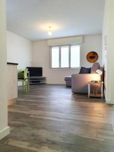 an empty living room with a couch and a tv at Myhouse Apartment in Cervignano del Friuli