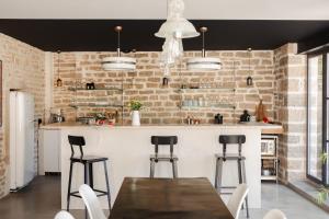 a kitchen with a table and chairs and a brick wall at La Cour de Beaune in Beaune