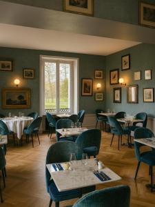 a restaurant with tables and chairs and a window at Domaine Du Roncemay - Hôtel, Restaurants, Spa & Golf in Aillant-sur-Tholon
