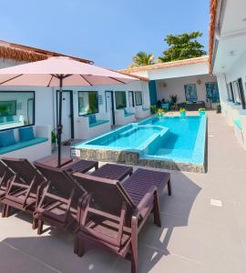a pool with chairs and an umbrella next to a house at LVIS blancura Hotel in Dharavandhoo