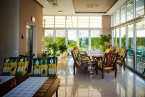 a dining room with a table and chairs and windows at Hotel Pervan in Međugorje