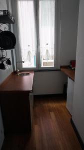 a kitchen with two windows and a wooden floor at Porto Vecchia Darsena in Savona +3 photos