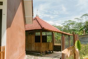 a wooden building with a red roof at Omah Ulin in Bandongan