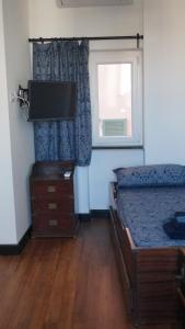 a bedroom with a bed and a tv and a window at Porto Vecchia Darsena in Savona