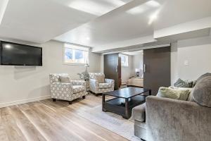 a living room with a couch and chairs and a tv at Bright & Cozy Central Retreat in Calgary
