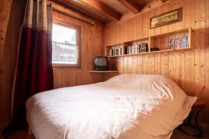a bedroom with a bed in a wooden cabin at Chalet Savoyard in La Clusaz